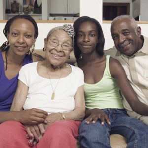 Couple sitting with their teenage daughter and mother in-law on a couch