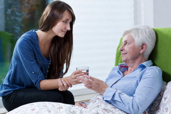 Caregiver spending quality time with a senior woman with Alzheimer's and her small dog in Durham North Carolina