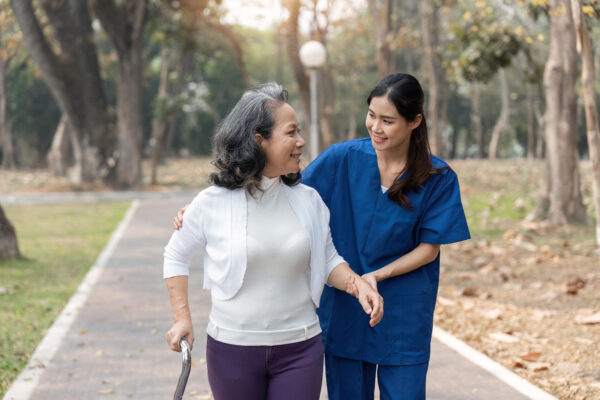 Caregiver assisting a senior woman using a walker in her Pittsboro North Carolina home after hospital discharge