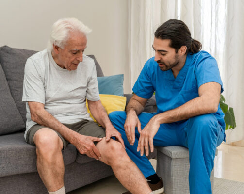 Older man with knee surgery gets help from male care aide